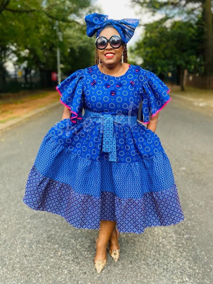 Blue patterned puff-sleeve heritage dress with tiered ruffles and adjustable waist tie