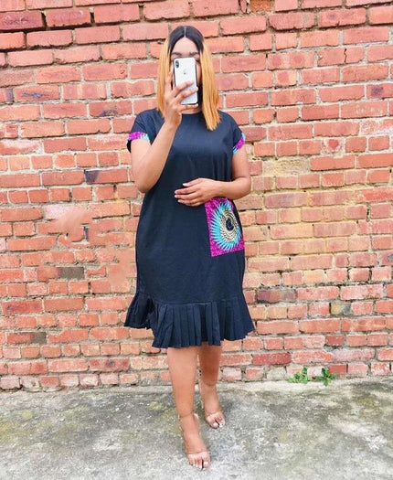 Black pleated-hem dress with colorful peacock-pattern pocket panel and short sleeves