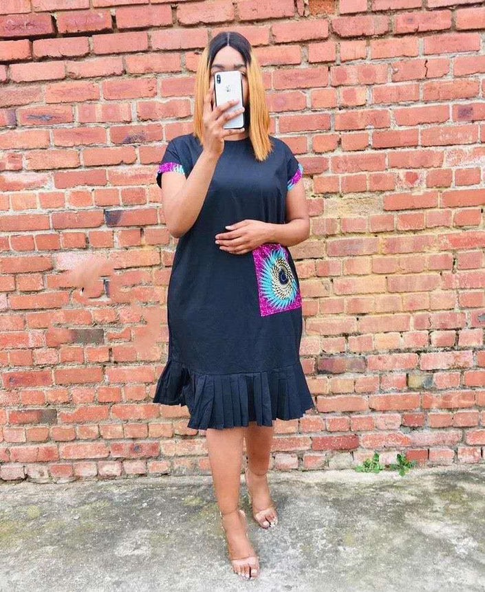 Black pleated-hem dress with colorful peacock-pattern pocket panel and short sleeves