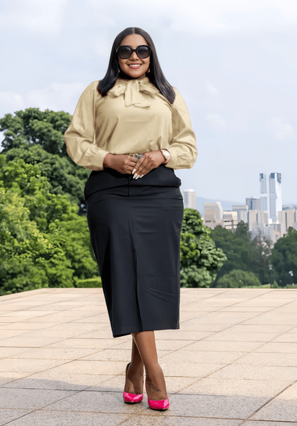 Beige long-sleeve bow-tie blouse with tied neck and gathered cuffs.