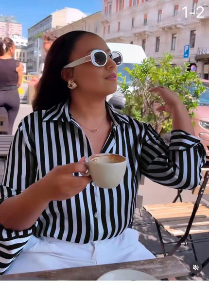 Black and white long-sleeve striped shirt with pointed collar and button front.
