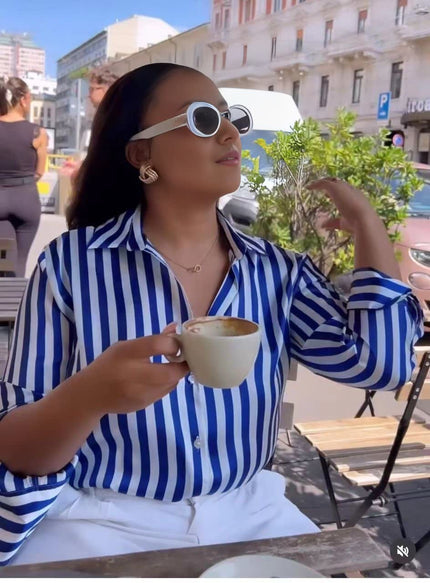 Blue and white long-sleeve striped shirt with pointed collar and button front.