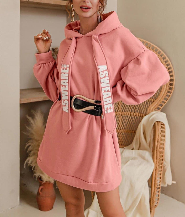 Oversized hoodie dress in light pink with front pocket and drawstring hood.