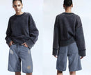 Distressed knee-length loose-fit denim shorts with rips at knees