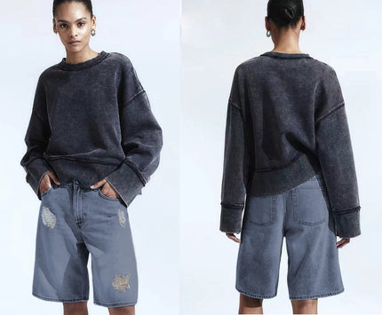 Distressed knee-length denim shorts with loose fit, dark wash, frayed rips at legs