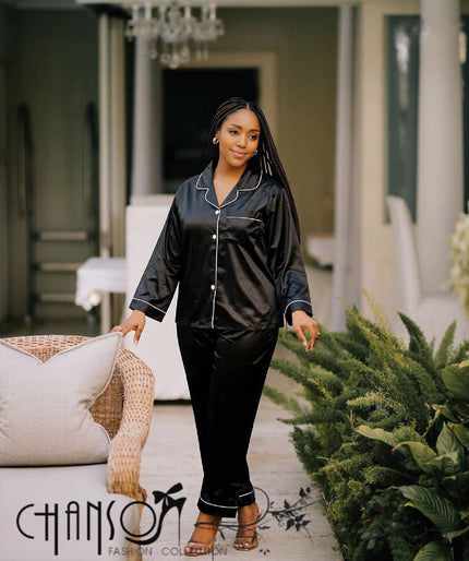 Black satin pajama set with white piping: long-sleeve top and matching pants