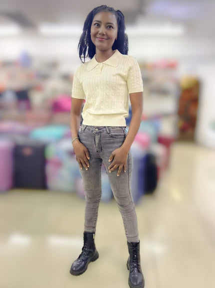 Light yellow cable-knit polo top with short sleeves and button placket