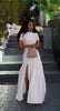 White maxi dress with short sleeves, fitted bodice, flared A-line skirt and high slit
