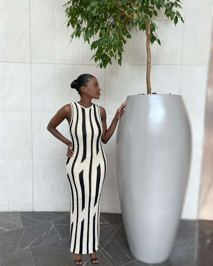 Sleeveless knit maxi dress with black and white vertical stripes, slim fit, high neck.