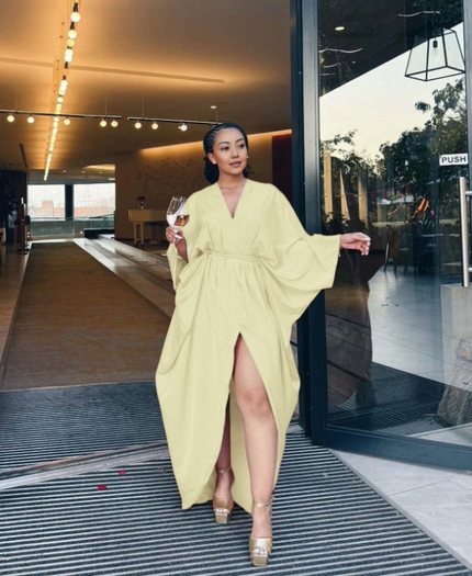 Pale yellow loose-fit maxi dress with V-neck, long sleeves, waist tie, and front split hem