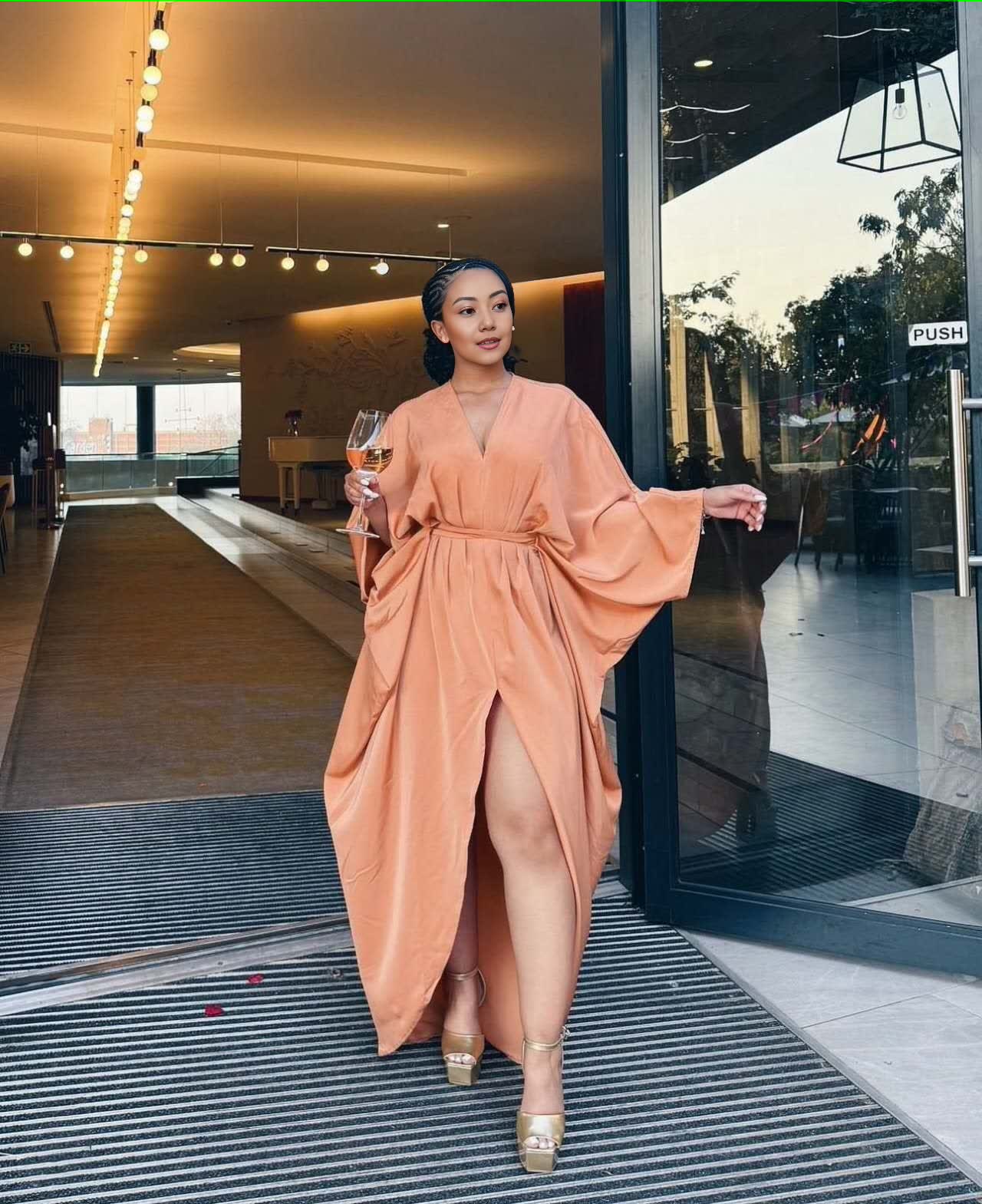 Peach loose-fit maxi dress with V-neck, long sleeves, waist tie, and front split hem