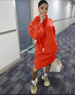 Orange-red hoodie dress with relaxed fit, front pocket, and long sleeves