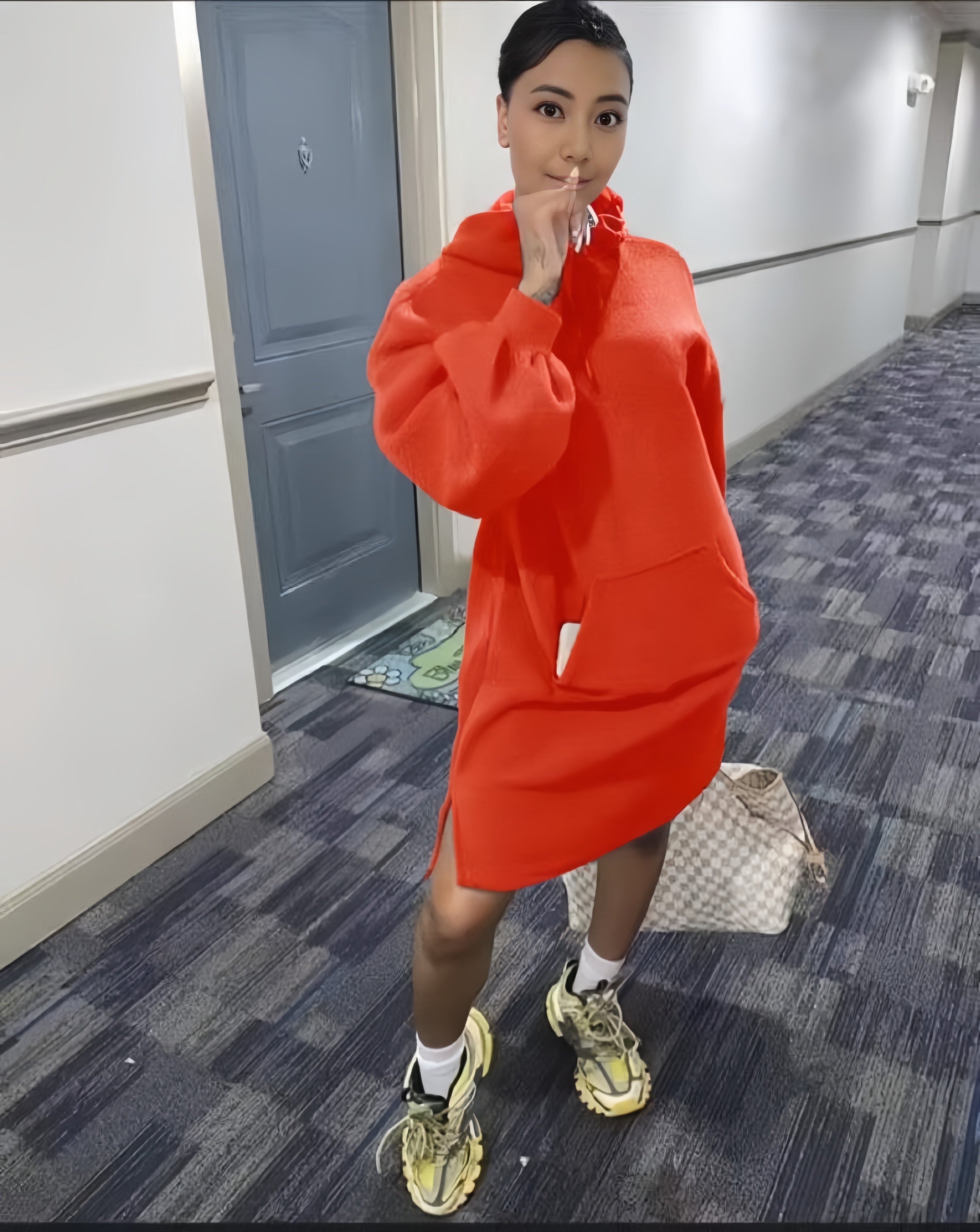 Orange-red hoodie dress with relaxed fit, front pocket, and long sleeves