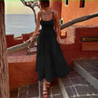 Black smocked bodice sleeveless dress with flared skirt and tiered pleats