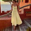 Light-yellow smocked bodice sleeveless dress with flared skirt and tiered pleats