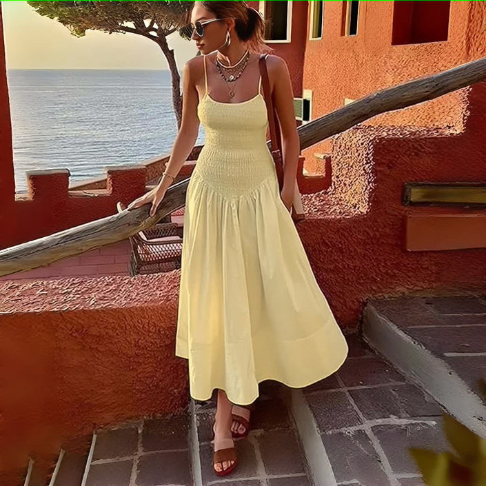Light-yellow smocked bodice sleeveless dress with flared skirt and tiered pleats