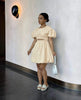 Tan mini dress with puff sleeves and cut-out waist, gathered skirt