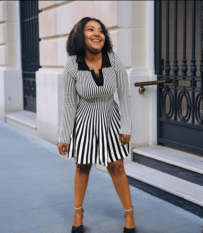 Pleated knit mini dress with vertical black-and-white stripes and V neckline