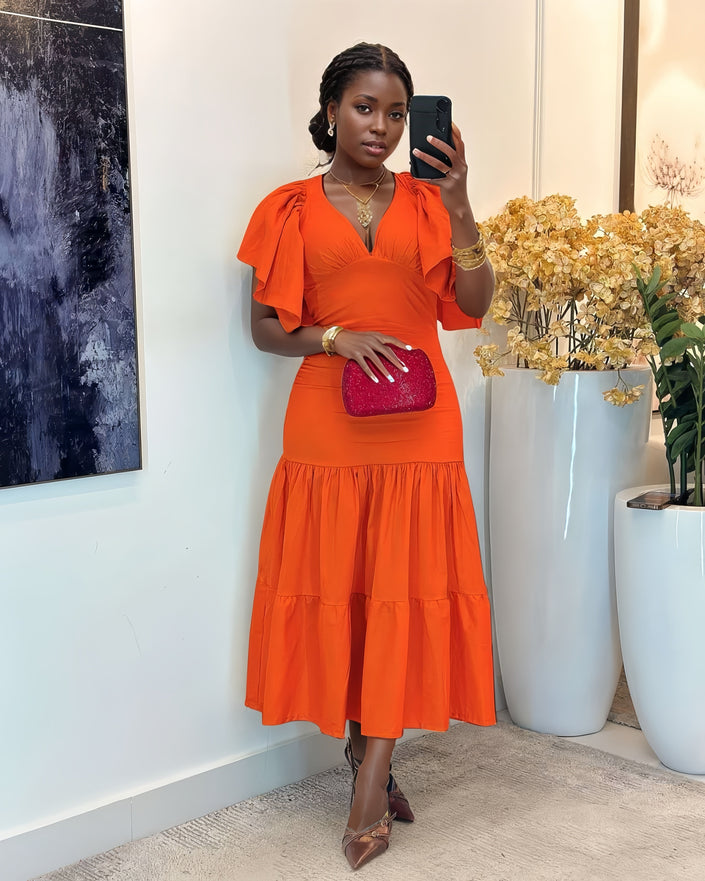Tiered midi dress in orange-red with flutter sleeves and fitted waist