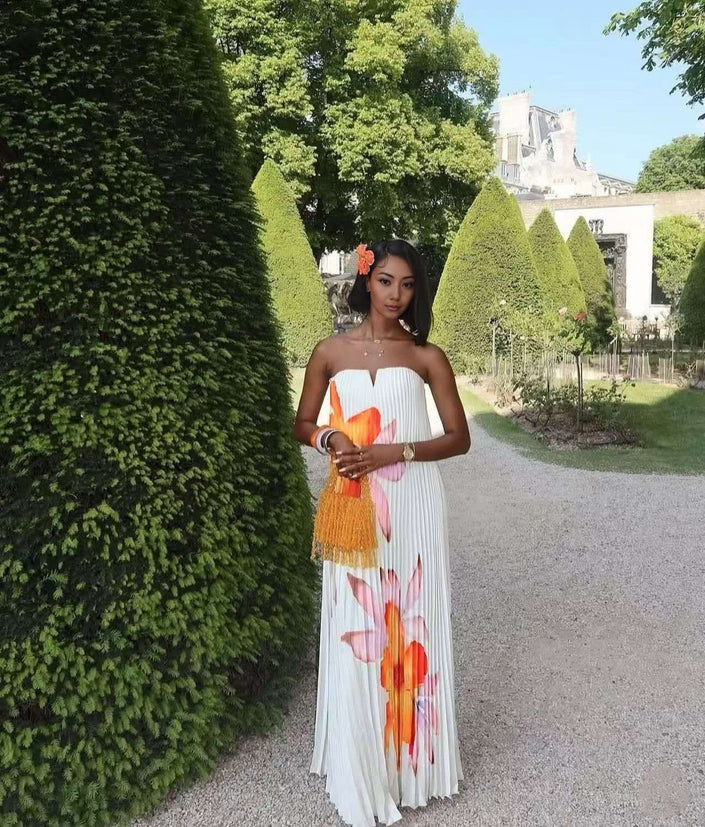 White strapless maxi dress with bold floral print, pleated bodice and flowing skirt