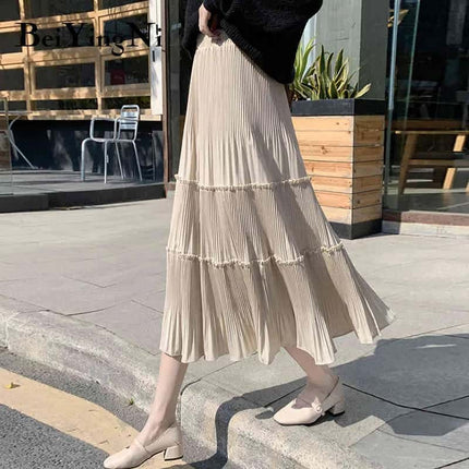 Tan tiered pleated midi skirt with stretch waist and tiered ruffle bands