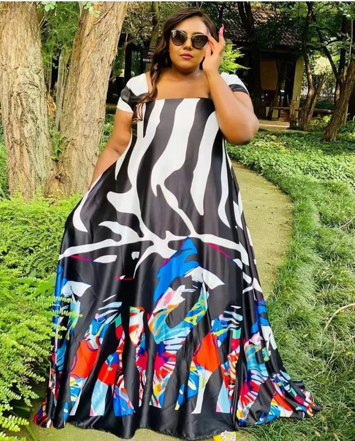 Plus size maxi dress with abstract animal print, black base with multicolor graphic hem