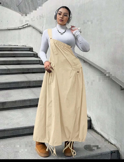 Beige maxi workwear dress with adjustable straps, front pockets, and gathered A-line skirt