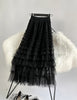 Black pleated layered midi skirt with ruffled tiers and tulle-like texture