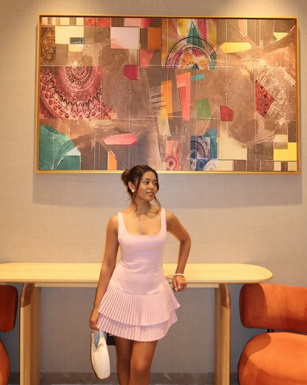 Light pink sleeveless pleated mini dress with tiered ruffle skirt and scoop neckline