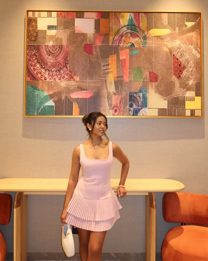 Light pink sleeveless pleated mini dress with tiered ruffle skirt and scoop neckline