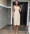 Nude pleated maxi dress with square neckline and gathered straps, flared skirt
