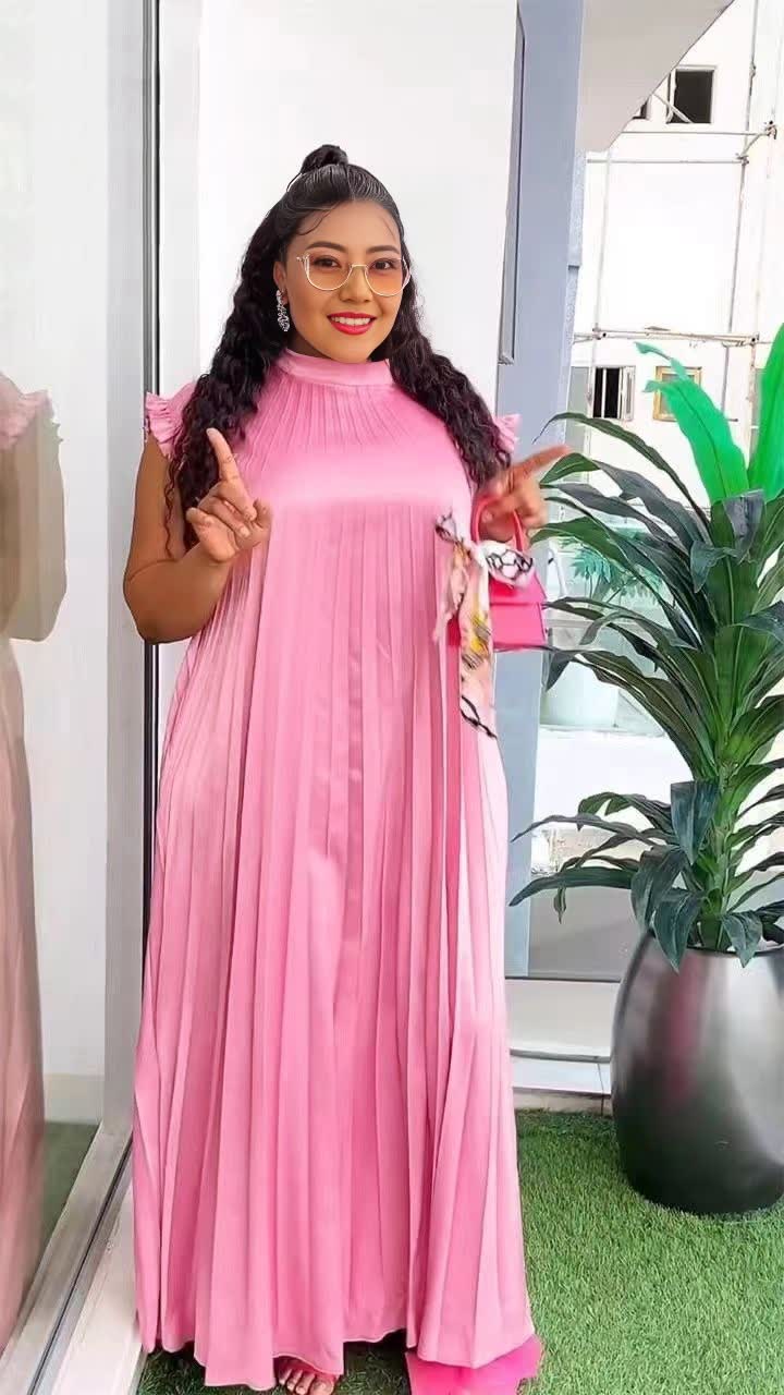 Light-pink pleated maxi dress with high neck and long flowing skirt