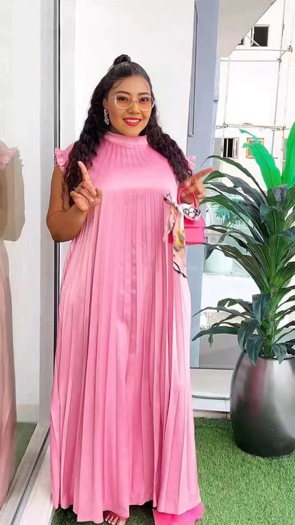 Light-pink pleated maxi dress with high neck and long flowing skirt