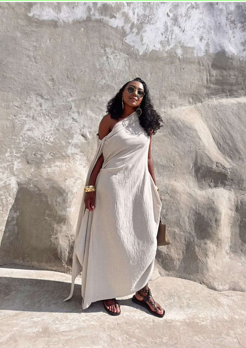Beige one-shoulder maxi dress with draped drapery and flowy layered silhouette