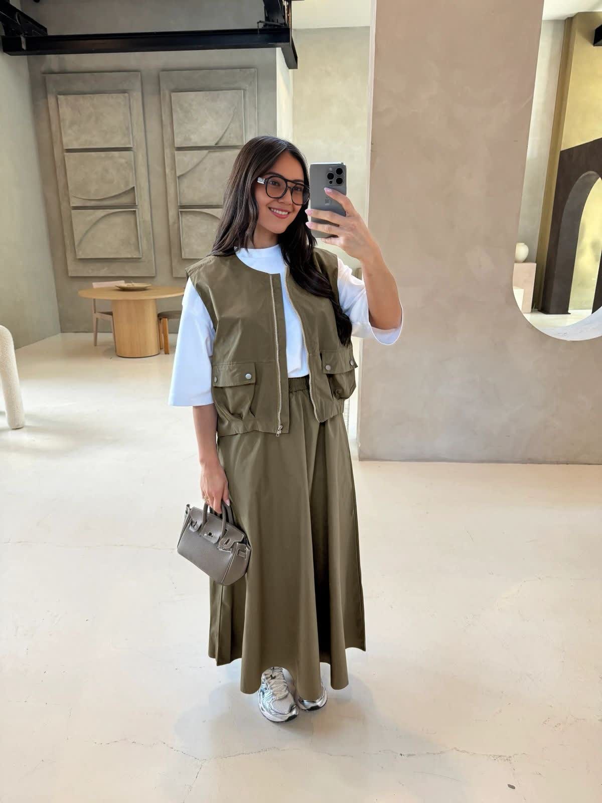 Army-green twin set: utility vest with zip and pockets over maxi skirt
