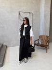 Black twin set: sleeveless utility vest with flap pockets over long maxi skirt