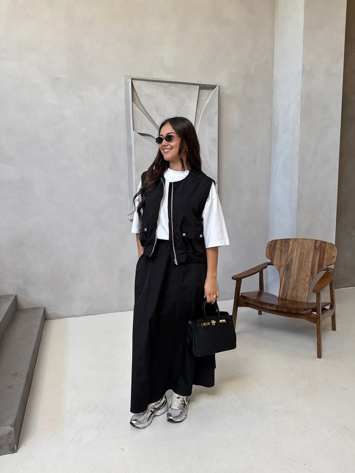 Black utility vest with chest pockets and matching maxi skirt, adjustable fit