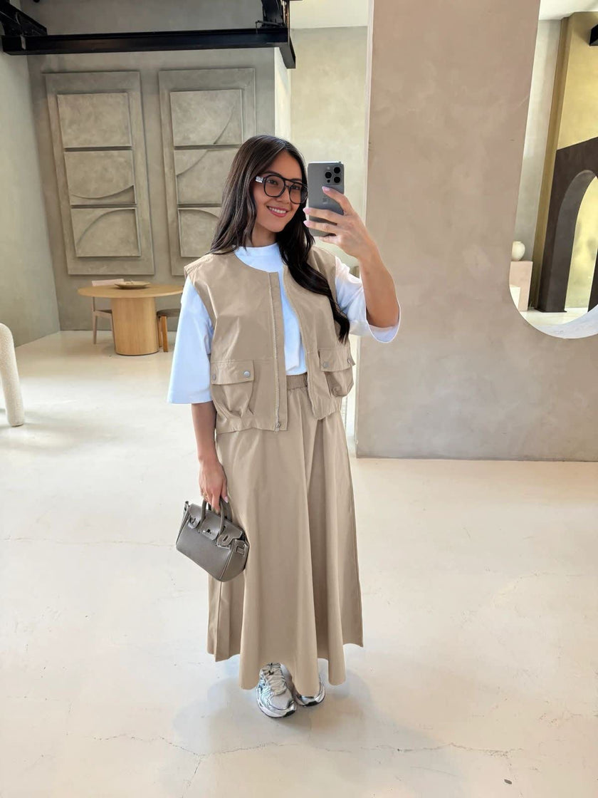 Beige twin set: utility vest with front straps and zip, paired with maxi skirt