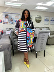 Abstract printed shirt dress with black-and-white striped panel, colorful front, long sleeves