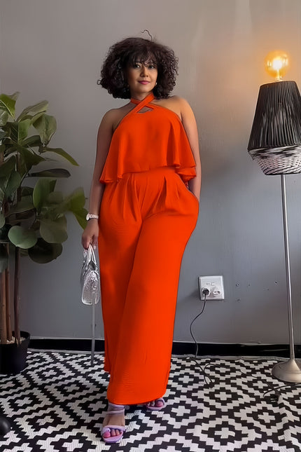 Orange sleeveless cross-neck jumpsuit with layered ruffle shoulder and wide legs