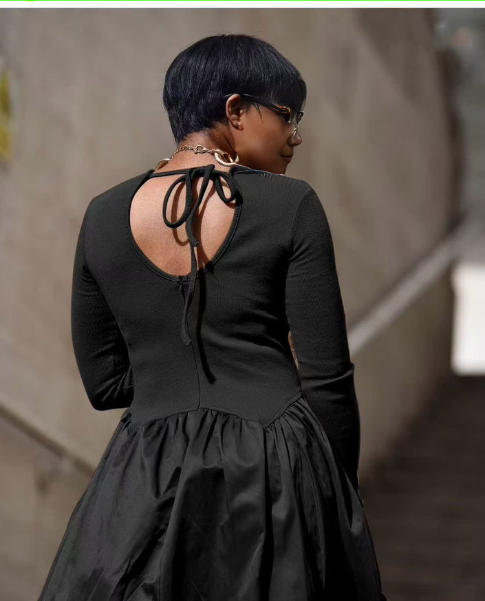 Black maxi dress with long sleeves, open back tie, and gathered tiered skirt