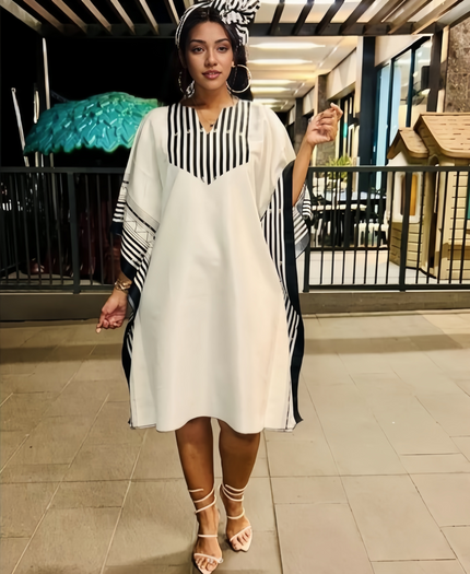 Plus size loose-fit stripe dress, white with black vertical striped V-neck yoke and long sleeves.