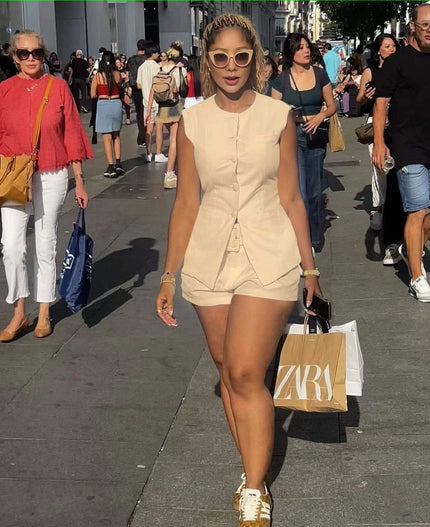 Sleeveless front-tie romper in light beige/cream with buttoned bodice and drawstring waist