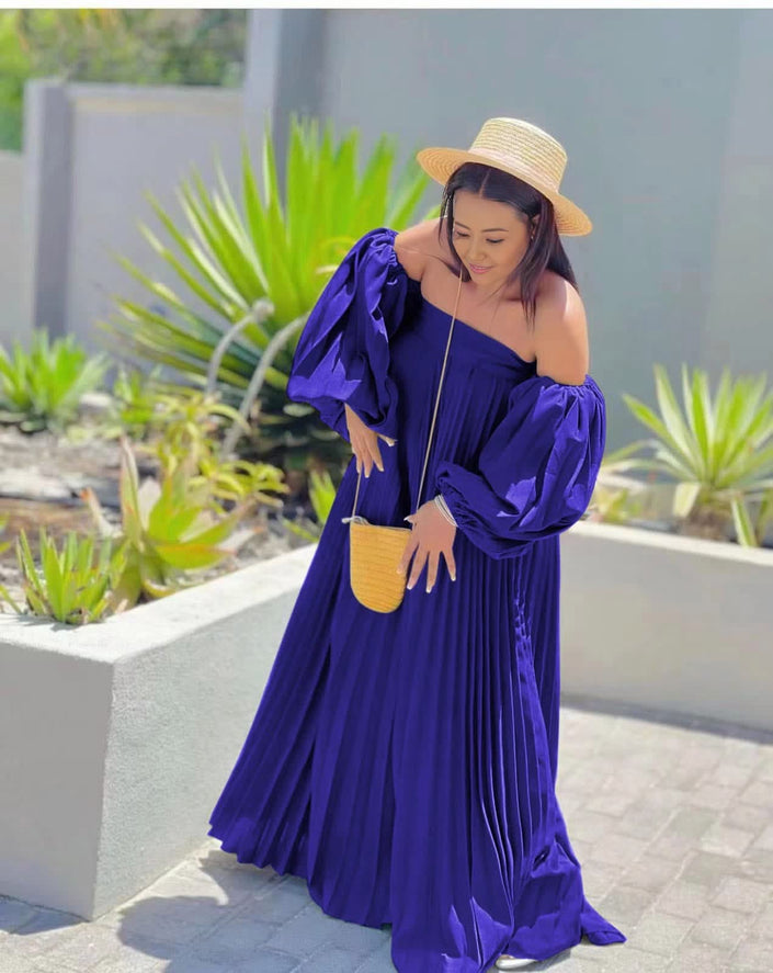Off-shoulder pleated maxi dress, dark blue puff sleeves.