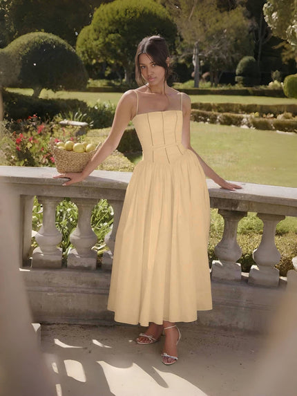 Tan midi dress with thin straps and fitted bodice, flared mid-length skirt