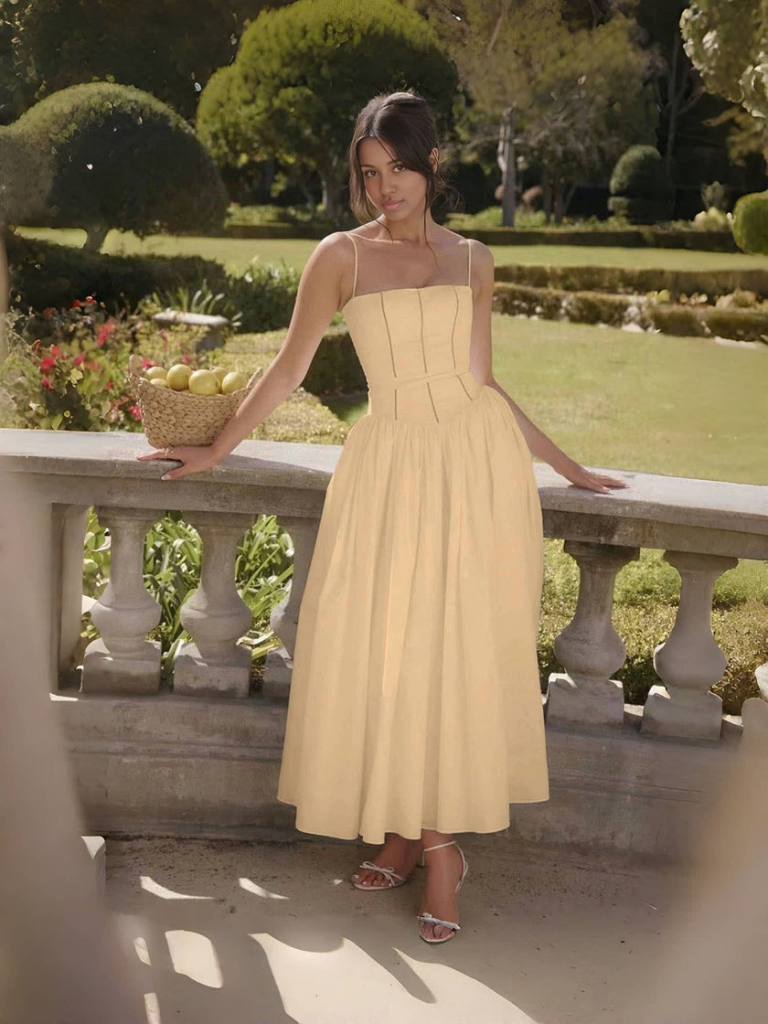 Tan midi dress with thin straps and fitted bodice, flared mid-length skirt