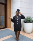 Black midi dress with long sleeves, five-button front, and round neckline detail.