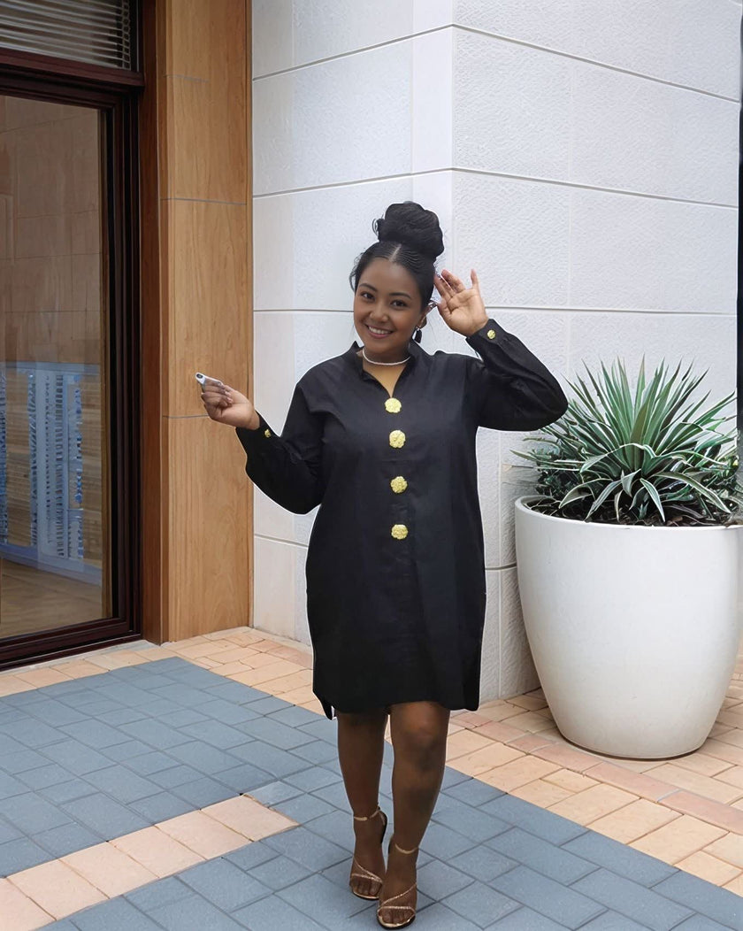 Black midi dress with long sleeves, five-button front, and round neckline detail.