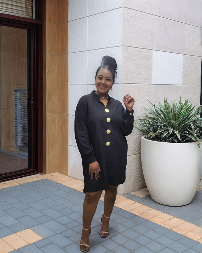 Black midi dress with long sleeves, five-button front, and round neckline.