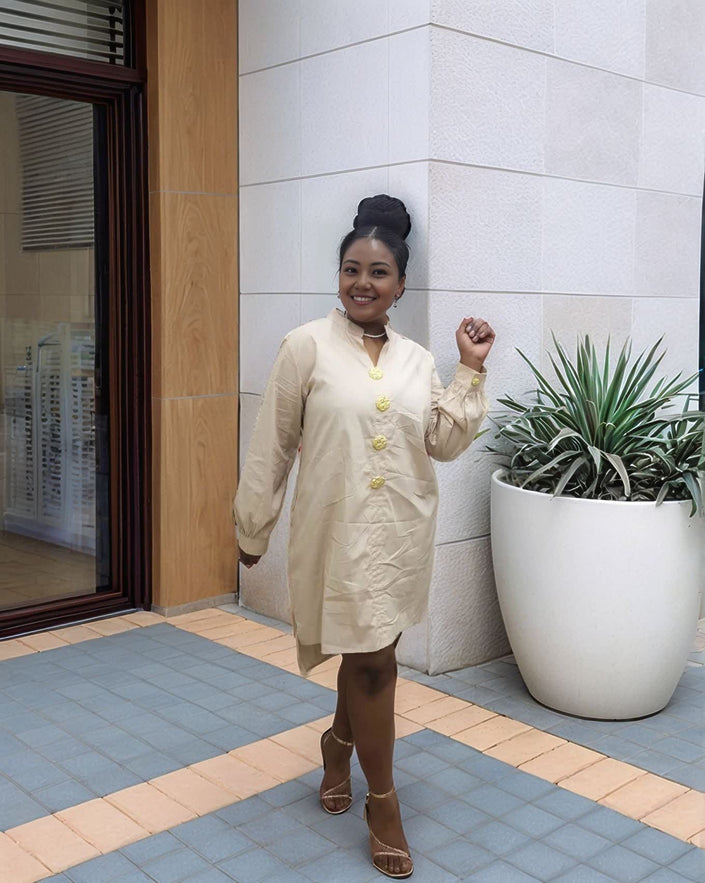 Nude/beige midi dress with long sleeves, five-button front, and round neckline.